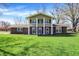 Charming two-story home with a brick facade, lush green lawn, and beautiful trees on a sunny day at 5311 Larita Ln, Anderson, IN 46017