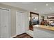Hallway view looking into kitchen and dining area with wood floors and white painted brick details at 5311 Larita Ln, Anderson, IN 46017