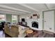 Cozy living room with brick fireplace, wood floors, and large windows with natural light at 5311 Larita Ln, Anderson, IN 46017