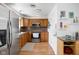 Well-lit kitchen with stainless steel appliances, oak cabinets and backsplash, complemented by wood-look vinyl flooring at 5357 Collett E Dr, Camby, IN 46113