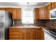Functional kitchen with warm wood cabinets, stainless steel sink, mosaic backsplash and ample counter space at 5357 Collett E Dr, Camby, IN 46113