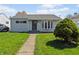Charming home featuring a well-maintained front lawn, gray siding and an inviting walkway leading to the front door at 5427 E 19Th St, Indianapolis, IN 46218