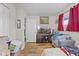Cozy living room features wood floors, media center, and window with bright red curtains at 5427 E 19Th St, Indianapolis, IN 46218