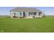 Expansive backyard with a well-manicured lawn, a stone fireplace, a patio, and an outdoor dining area at 5679 S 675 W, New Palestine, IN 46163
