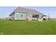 Lush backyard featuring a well-kept lawn, patio with seating and dining, and a stone fireplace, ideal for outdoor living at 5679 S 675 W, New Palestine, IN 46163