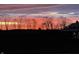 A barn's silhouette stands majestically against a vibrant sunset sky, showcasing its timeless beauty in a serene setting at 5679 S 675 W, New Palestine, IN 46163