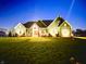 Inviting home exterior illuminated at night, showcasing the well-lit façade and manicured lawn at 5679 S 675 W, New Palestine, IN 46163