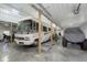 Spacious garage featuring a Class A RV, an ATV, and covered off-road vehicle, offering ample storage and workspace at 5679 S 675 W, New Palestine, IN 46163