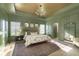 Elegant main bedroom with green walls, a tray ceiling, a decorative chandelier, and natural light at 5679 S 675 W, New Palestine, IN 46163