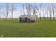 Quaint outbuilding with glass-enclosed porch, surrounded by green lawn and bare trees, adding charm and versatility at 5679 S 675 W, New Palestine, IN 46163