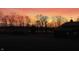Stunning sunrise view with silhouette of trees and farm buildings, creating a serene rural ambiance at 5679 S 675 W, New Palestine, IN 46163