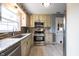 Bright kitchen features granite countertops, mosaic backsplash, stainless steel appliances, and ample cabinetry at 5735 Brouse Ave, Indianapolis, IN 46220