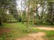 A private, wooded backyard with beautiful green grass and mature shade trees provides a serene outdoor experience at 5820 Bonnie Brae St, Indianapolis, IN 46228