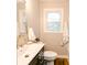 Bright bathroom featuring a single sink vanity, white toilet and shower at 5820 Bonnie Brae St, Indianapolis, IN 46228