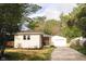 Charming home featuring a detached garage, wood deck, and gravel driveway lined with trees at 5820 Bonnie Brae St, Indianapolis, IN 46228
