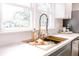 Updated kitchen with a gold faucet, white countertops, and gray backsplash at 5820 Bonnie Brae St, Indianapolis, IN 46228