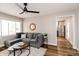 Bright living room with a gray sofa, ceiling fan, and views of the backyard at 5820 Bonnie Brae St, Indianapolis, IN 46228