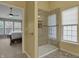 Bright bathroom featuring a tiled shower with glass door and view into the main bedroom at 6037 Porter Ln, Noblesville, IN 46062