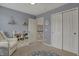 Bedroom featuring gray walls, a white glider, a bookshelf, and a changing table at 6037 Porter Ln, Noblesville, IN 46062