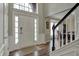 Inviting foyer with hardwood floors, staircase, and natural light from the large window above the front door at 6037 Porter Ln, Noblesville, IN 46062