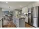 Open concept kitchen with an island, stainless steel refrigerator, and access to the dining area at 6037 Porter Ln, Noblesville, IN 46062