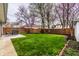 Spacious backyard with patio area, grill, lush lawn, and flowering trees creates a serene oasis at 6041 Garver Rd, Indianapolis, IN 46208