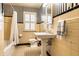 Bathroom with striped wallpaper, a classic pedestal sink, and a shower/tub combo at 6041 Garver Rd, Indianapolis, IN 46208
