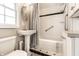 Well-lit bathroom featuring a pedestal sink, shower and tub combination, and classic tile work at 6041 Garver Rd, Indianapolis, IN 46208