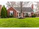 Charming brick home featuring manicured lawn, classic architectural details and a welcoming front entrance at 6041 Garver Rd, Indianapolis, IN 46208