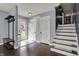 Inviting entryway with dark wood floors, fresh paint, and staircase with runner at 6377 Green Leaves Rd, Indianapolis, IN 46220
