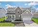 Charming two-story home with a stone facade, gray siding, and a well-manicured front lawn at 6557 Eagles Nest Ln, McCordsville, IN 46055