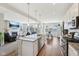 Open-concept kitchen and living area, with stainless steel appliances, a kitchen island, and a fireplace at 6557 Eagles Nest Ln, McCordsville, IN 46055