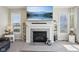 Cozy living room featuring a fireplace with stone surround and built-in shelving on each side at 6557 Eagles Nest Ln, McCordsville, IN 46055