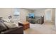 Open living area with comfortable seating, a TV, and a staircase with wooden railing at 6557 Eagles Nest Ln, McCordsville, IN 46055