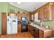 Well-lit kitchen with wooden cabinets, laminate flooring, and modern appliances, including a white refrigerator at 760 Sable Ridge Dr, Greenwood, IN 46142