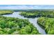 Beautiful aerial view of a winding lake surrounded by vibrant green forest, showcasing the natural beauty of the area at 7809 S Solitude Ln, Trafalgar, IN 46181