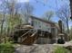 Charming back exterior with deck, patio furniture, and a golf cart parked on the gravel driveway at 7809 S Solitude Ln, Trafalgar, IN 46181