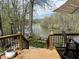 Outdoor deck with furniture overlooking lake, surrounded by trees and a manicured backyard at 7809 S Solitude Ln, Trafalgar, IN 46181