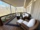 Covered deck with stylish furniture and a cozy fire pit for outdoor living at 7809 S Solitude Ln, Trafalgar, IN 46181