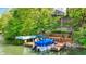 Lake house featuring a private dock and boat slip, stairs leading up to the home, and lush green surroundings at 7809 S Solitude Ln, Trafalgar, IN 46181