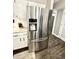 Stainless steel refrigerator with water dispenser complementing the white cabinets and granite countertops at 7809 S Solitude Ln, Trafalgar, IN 46181