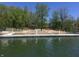 View of a lake beach area from the dock featuring beach and chairs and a lake to enjoy at 7809 S Solitude Ln, Trafalgar, IN 46181