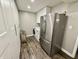 Functional laundry area featuring a stainless steel refrigerator, washer/dryer, and built-in storage at 7809 S Solitude Ln, Trafalgar, IN 46181