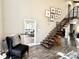 Living room with staircase with metal railing, exposed beams, and access to outdoor deck at 7809 S Solitude Ln, Trafalgar, IN 46181