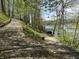 Scenic gravel path lined with trees leading down to a lake dock and boat lift at 7809 S Solitude Ln, Trafalgar, IN 46181