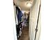 Walk-in closet with wood floor, light, lots of hanging storage and shelving at 7809 S Solitude Ln, Trafalgar, IN 46181