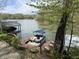 Waterfront view featuring a boat dock and a pontoon boat with seating, surrounded by trees at 7809 S Solitude Ln, Trafalgar, IN 46181