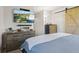 Spacious bedroom featuring a dresser, mounted TV, and a barn-style closet door at 8017 Wallingwood Dr, Indianapolis, IN 46256