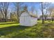 Charming white shed with double doors and a pitched roof, nestled in a grassy backyard at 8017 Wallingwood Dr, Indianapolis, IN 46256