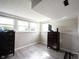 Finished basement area with two windows, gray walls, and wood grain laminate flooring at 8075 N Cardinal W Cv, Indianapolis, IN 46256